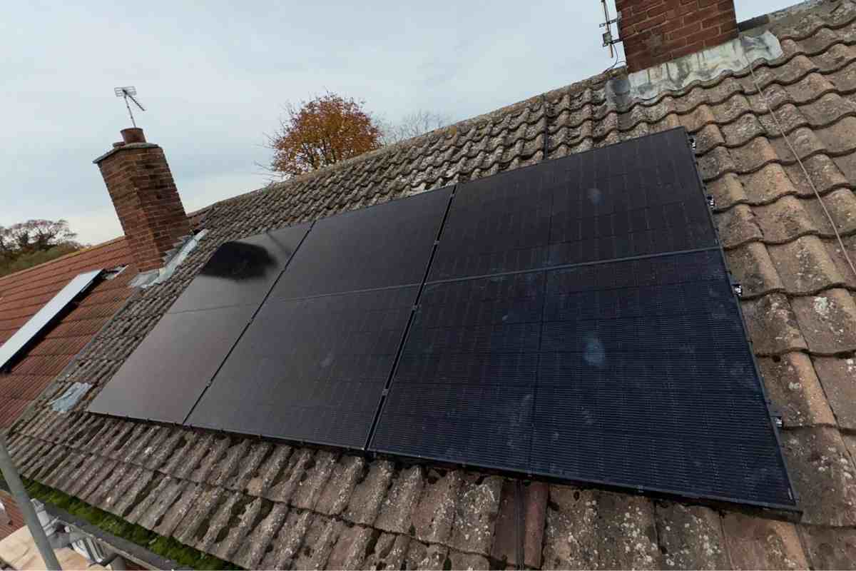 Six all-black solar panels on a tiled pitched roof.