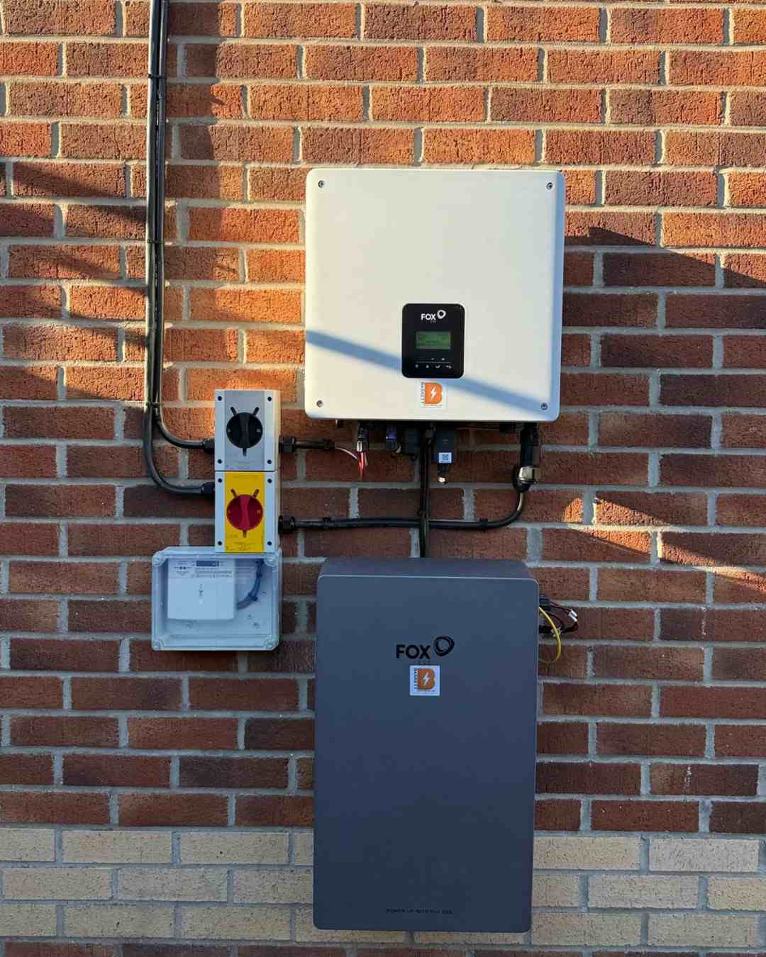 FOX ESS hybrid inverter and EP6 battery mounted on a brick wall.
